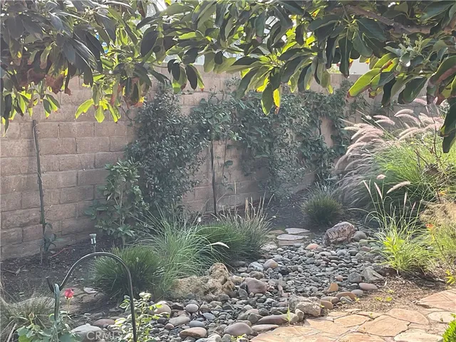 a backyard of a house with lots of green space and fountain in the back