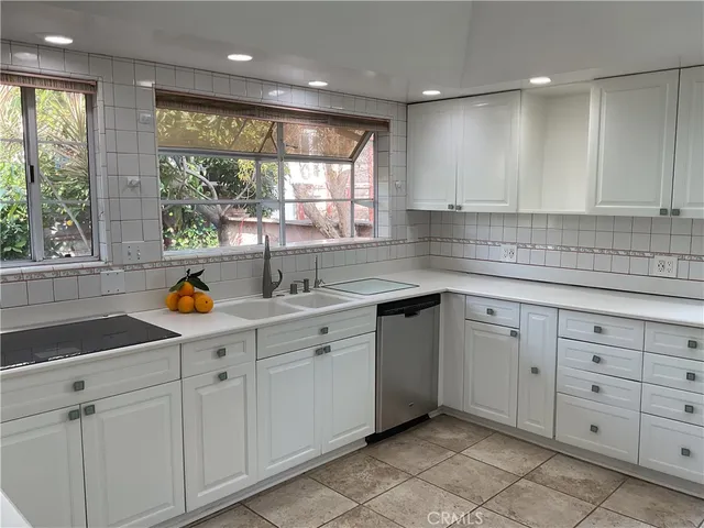 en empty room with windows and chandelier fan