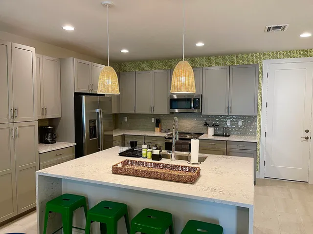 a kitchen with kitchen island granite countertop a sink a stove and refrigerator