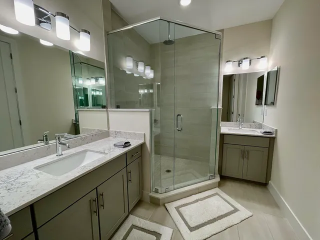 a bathroom with a shower sink and mirror