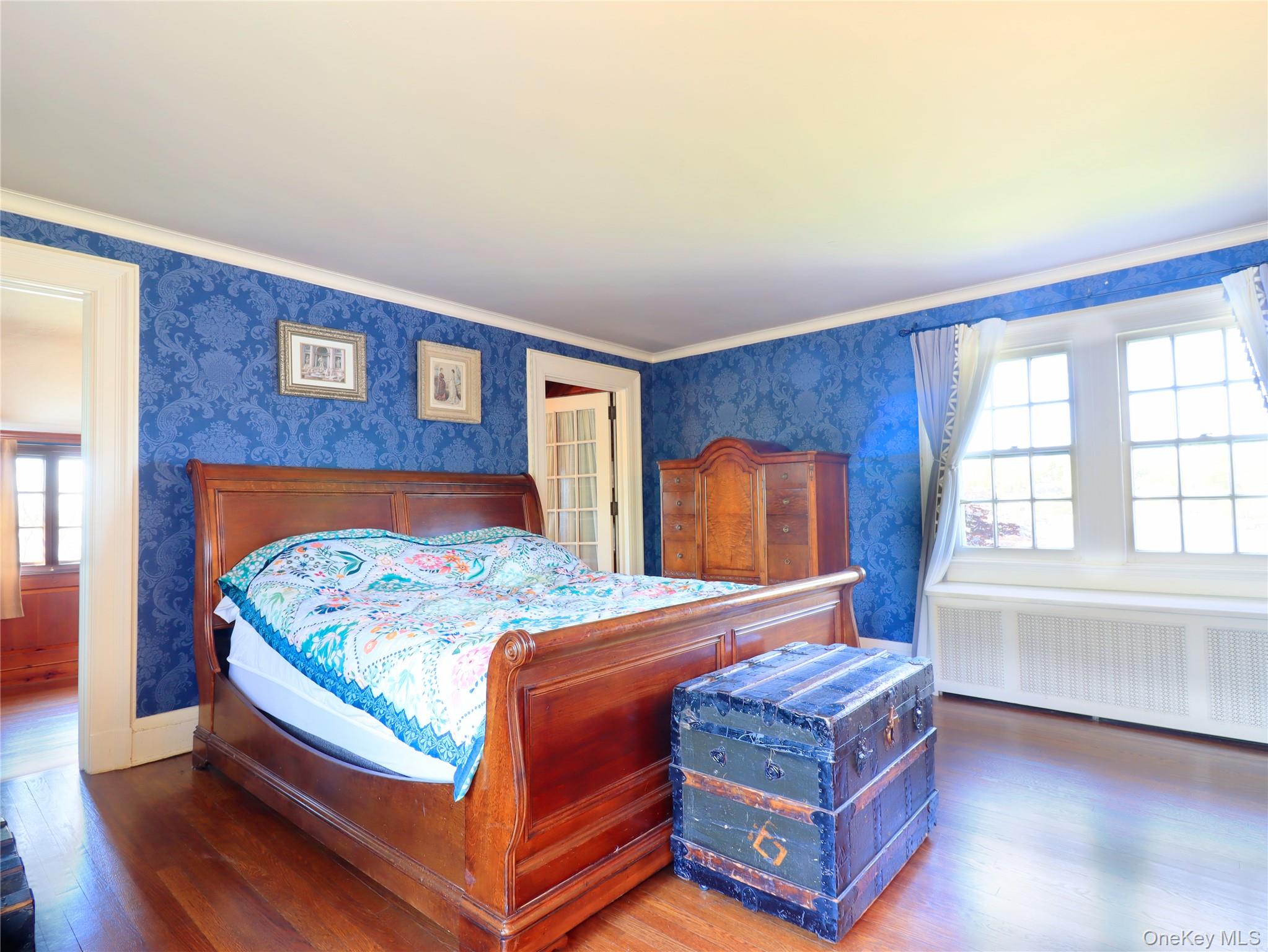 11-20 Shore Road Queens, NY 11363 - Photo 37 of 45 Room featuring rich hardwood flooring, ornate blue patterned wall covering, double French doors, large multi-pane windows, and a built-in radiator cover