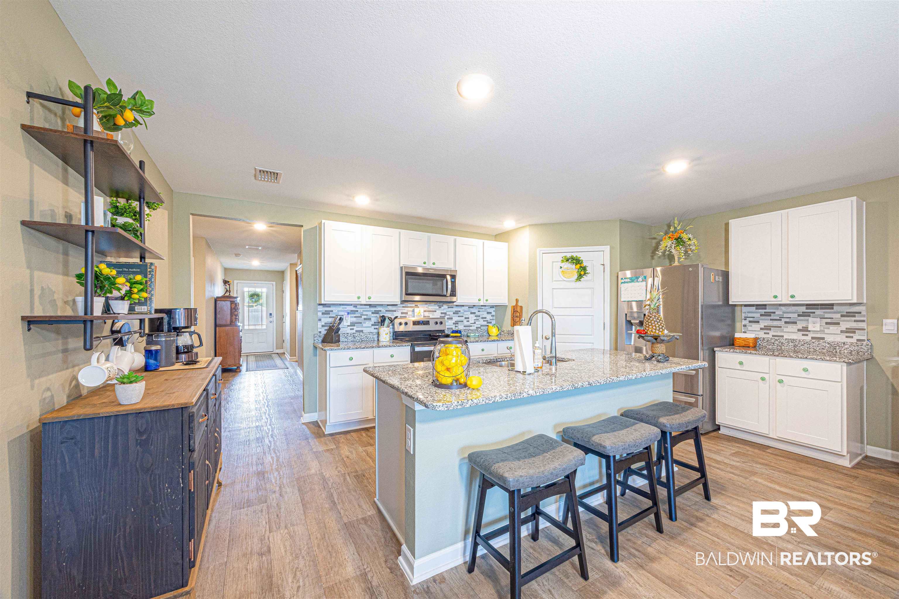 14843 Forsythia Loop Silverhill, AL 36576 - Photo 13 of 51 Kitchen featuring stainless steel appliances, white cabinetry, a breakfast bar area, light wood-type flooring, and open shelves