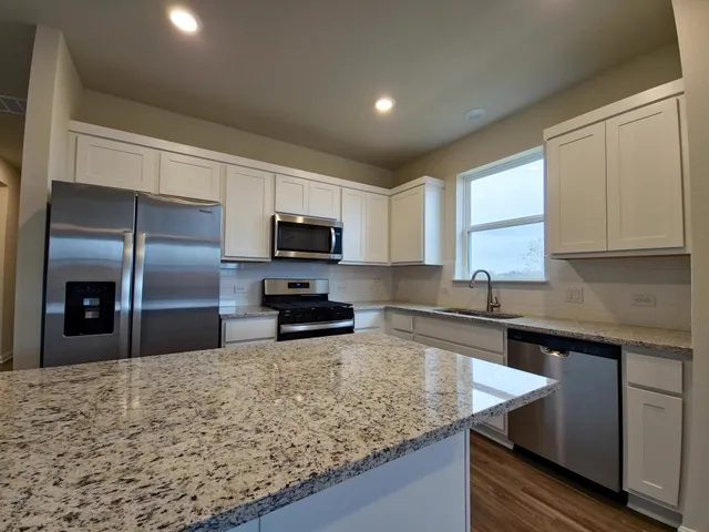 a kitchen with sink a microwave and refrigerator