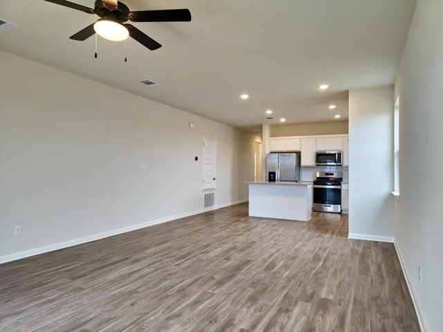 a view of a kitchen with a sink and dishwasher a refrigerator with wooden floor