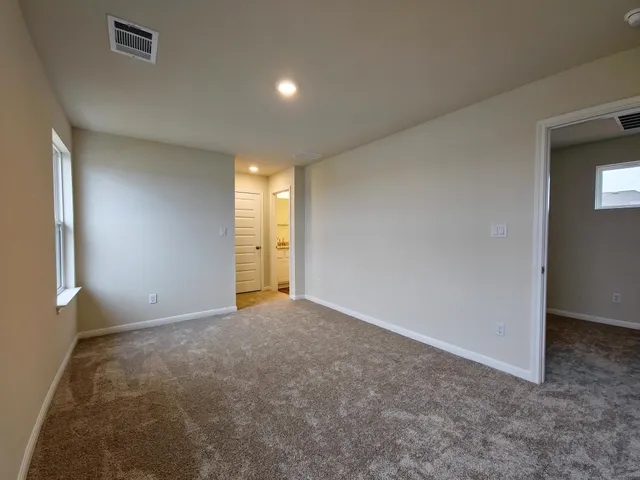 a view of an empty room with window and fire place