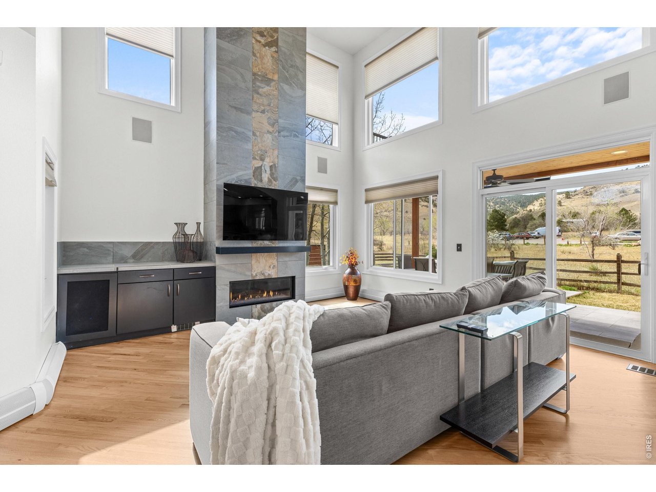 4825 6th Street Boulder, CO 80304 - Photo 4 of 50 a living room with furniture a flat screen tv and a floor to ceiling window