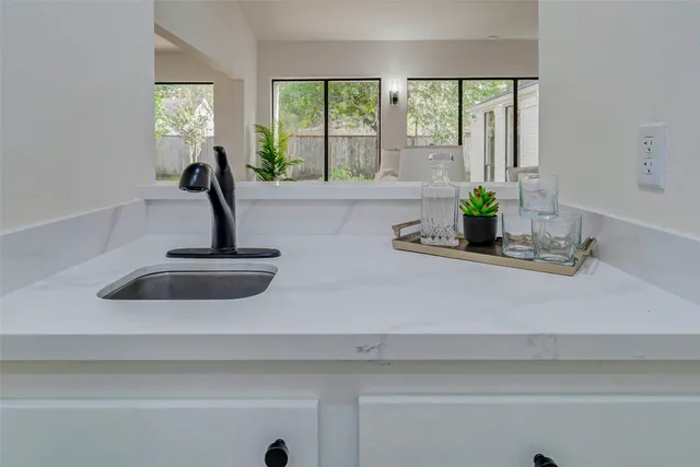 a kitchen with a sink a window and wooden floor