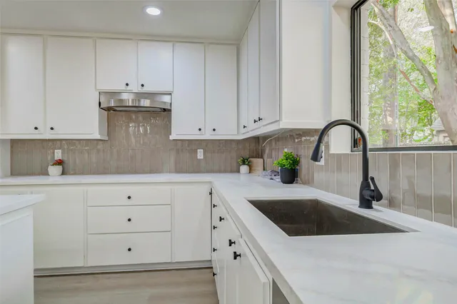 a kitchen with white cabinets and a sink