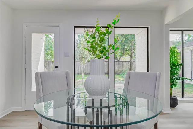 a view of a dining room with furniture a potted plant and wooden floor