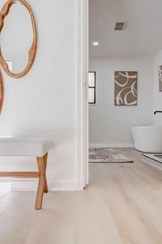 a view of a livingroom with wooden floor and a potted plant