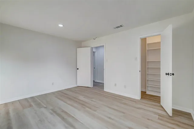 a view of walk in closet with empty racks