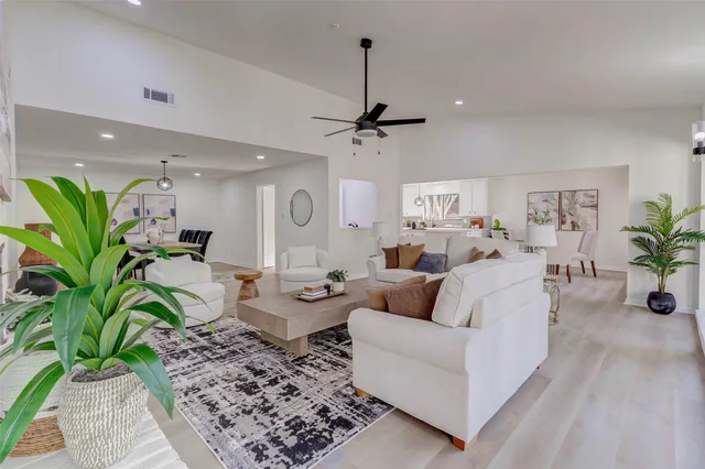 a living room with furniture a chandelier and a rug