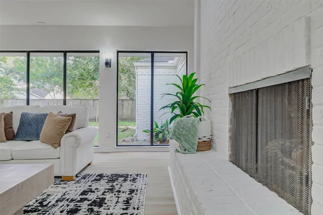a living room with a large window and potted plants