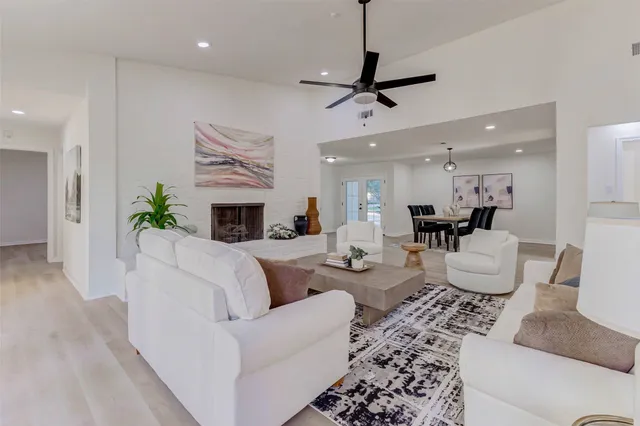 a living room with furniture a fireplace and a chandelier