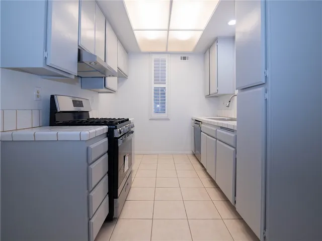 a kitchen with stainless steel appliances a sink stove and cabinets