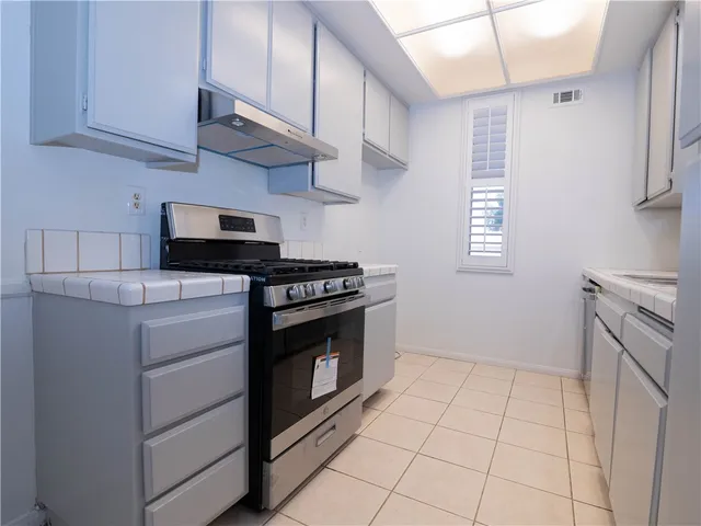 a kitchen with granite countertop a stove a sink and a microwave