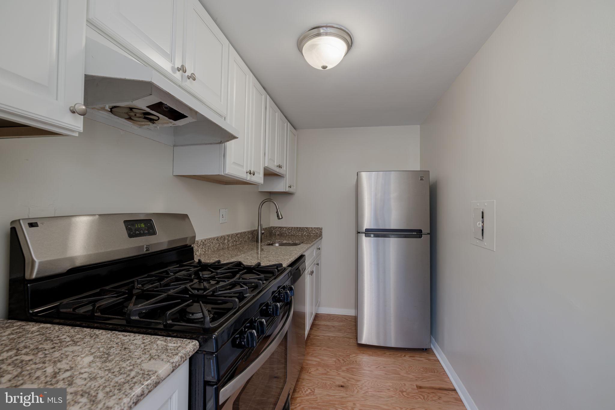 4000 Tunlaw Road Northwest, Unit 600 Washington, DC 20007 - Photo 11 of 27 a kitchen with stainless steel appliances granite countertop a refrigerator and a stove