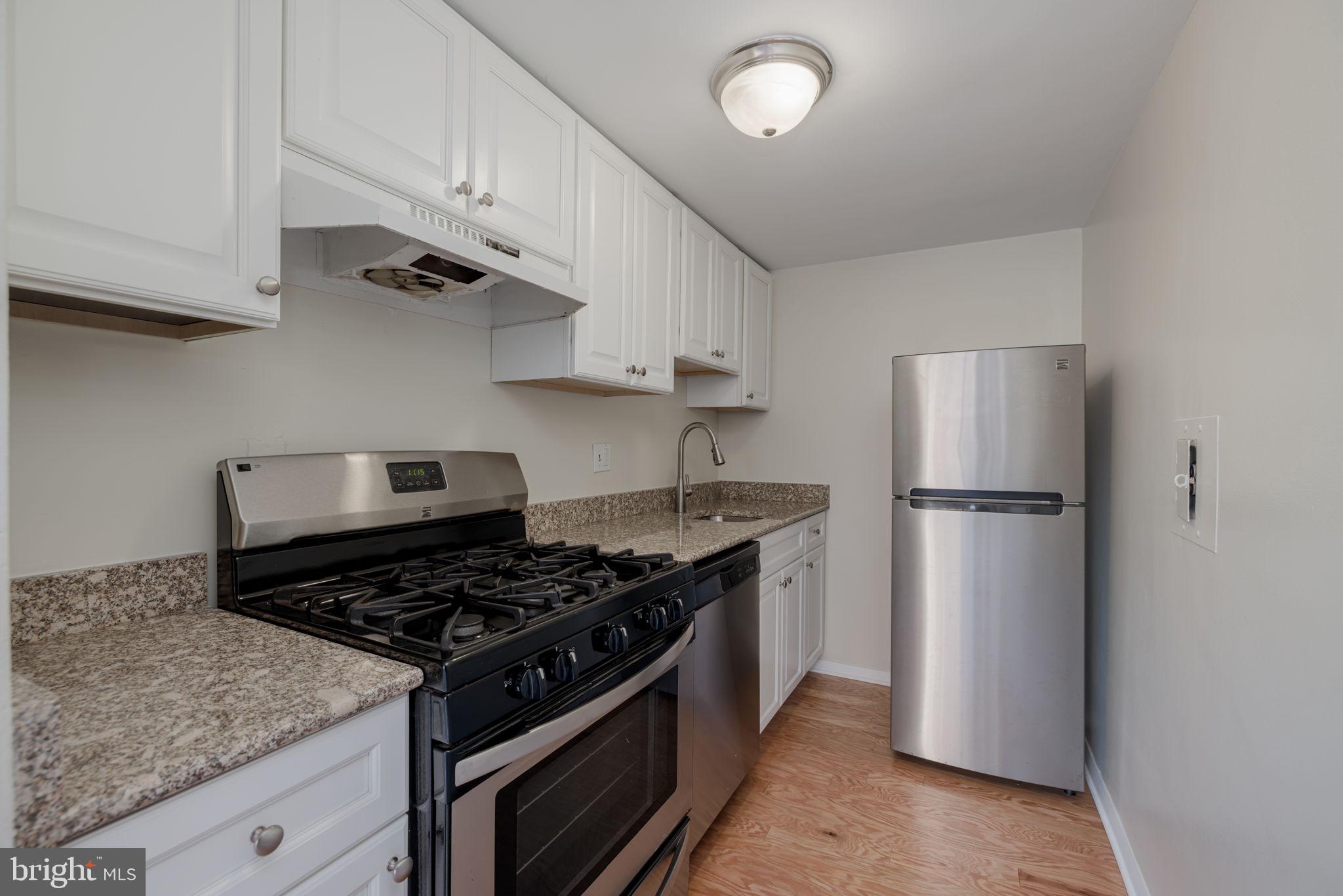 4000 Tunlaw Road Northwest, Unit 600 Washington, DC 20007 - Photo 10 of 27 a kitchen with stainless steel appliances granite countertop a refrigerator and a stove