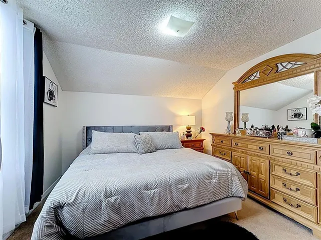 a bedroom with a bed and a dresser
