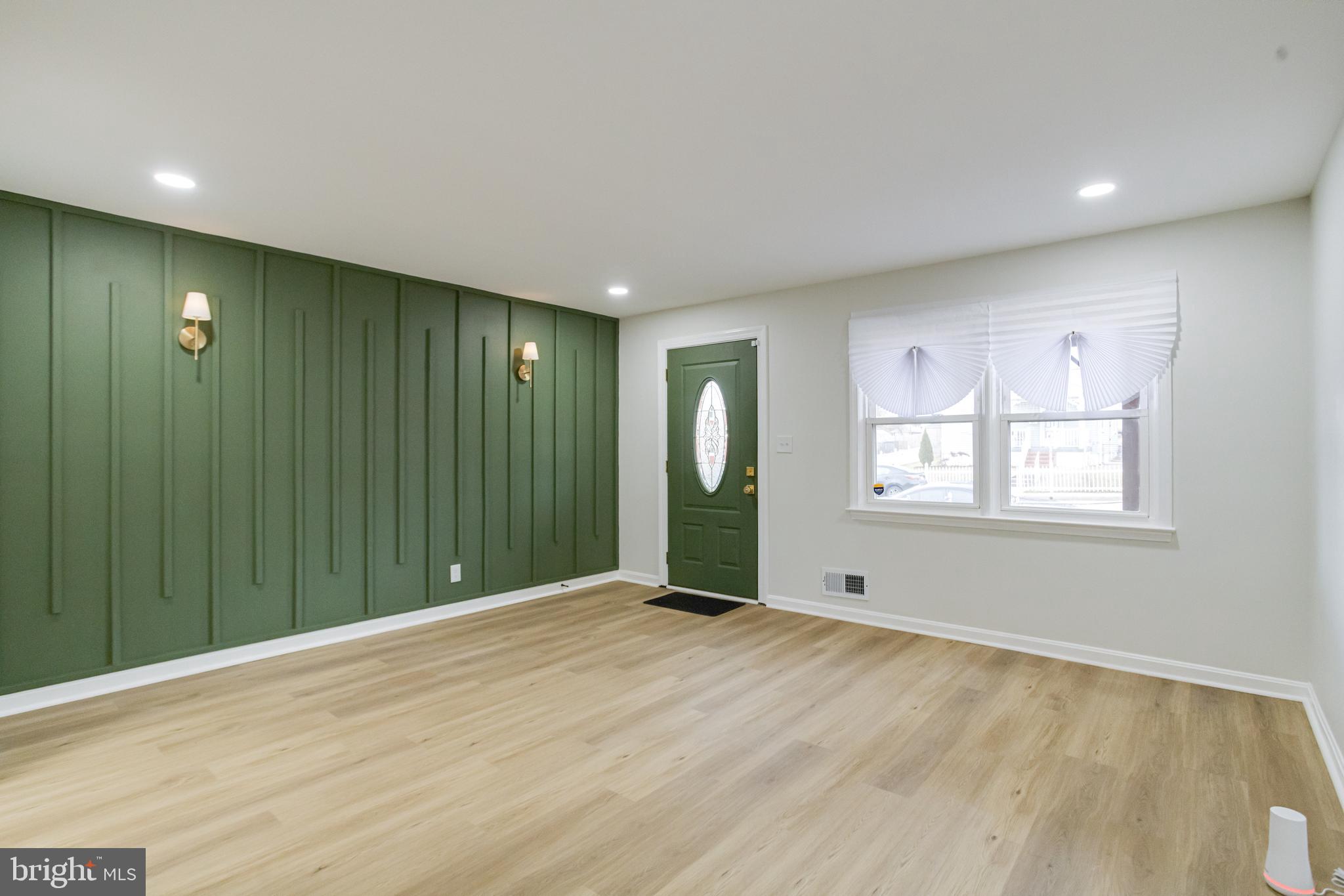 3916 2nd Street Baltimore, MD 21225 - Photo 2 of 20 a view of an empty room with wooden floor and windows