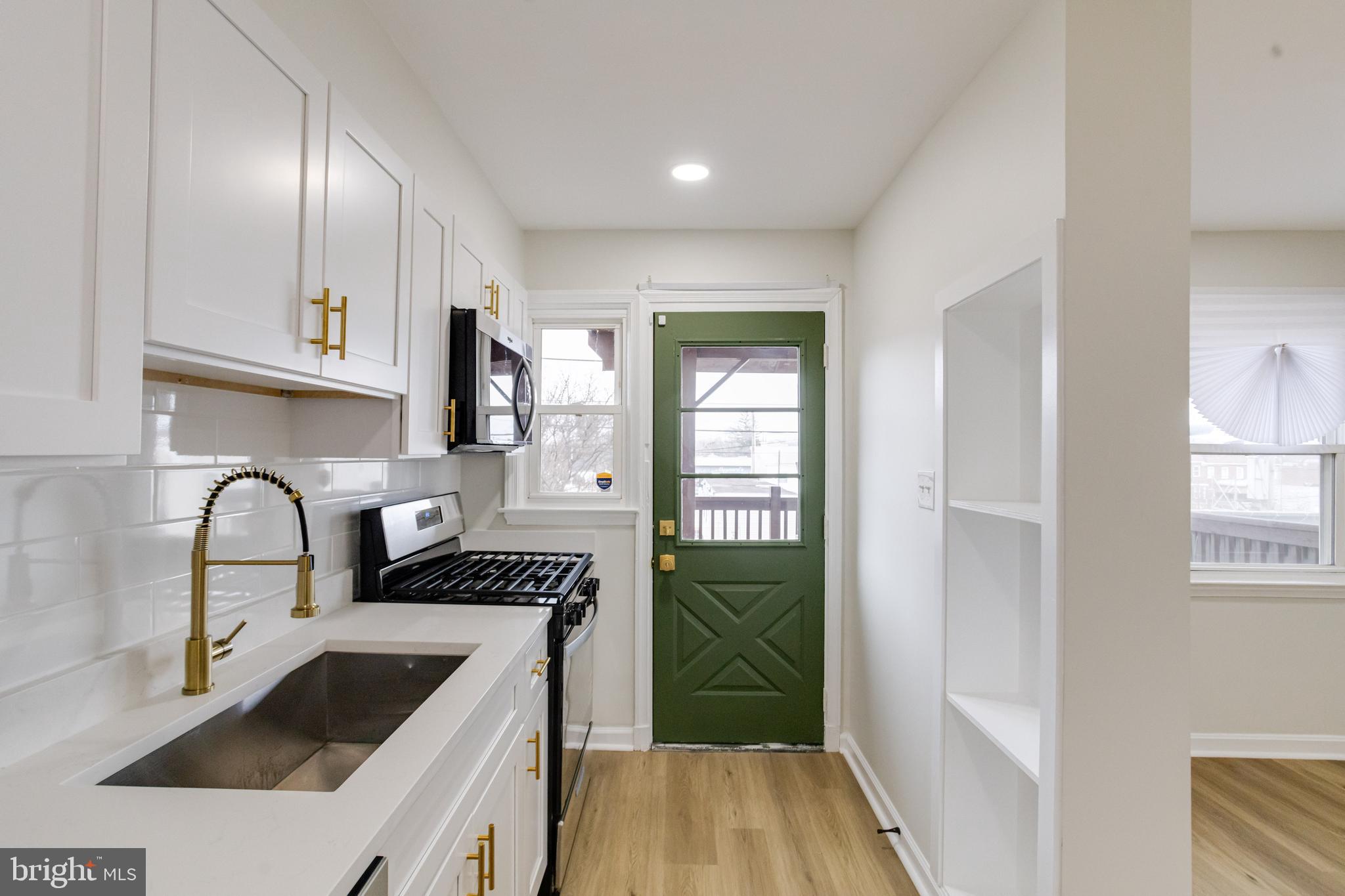 3916 2nd Street Baltimore, MD 21225 - Photo 5 of 20 a kitchen with granite countertop a sink and a stove top oven