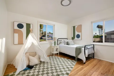 a bedroom with a bed and wooden floor