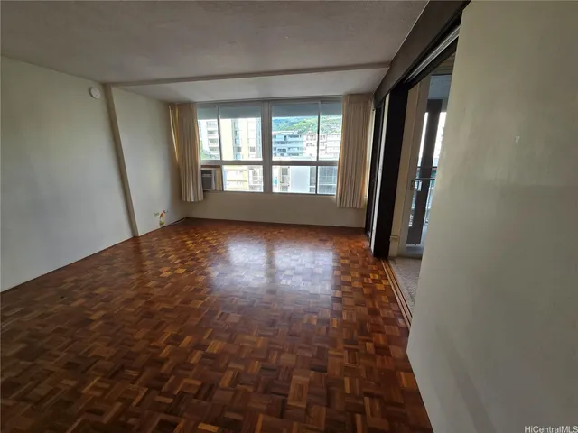 a view of hallway with window and wooden floor
