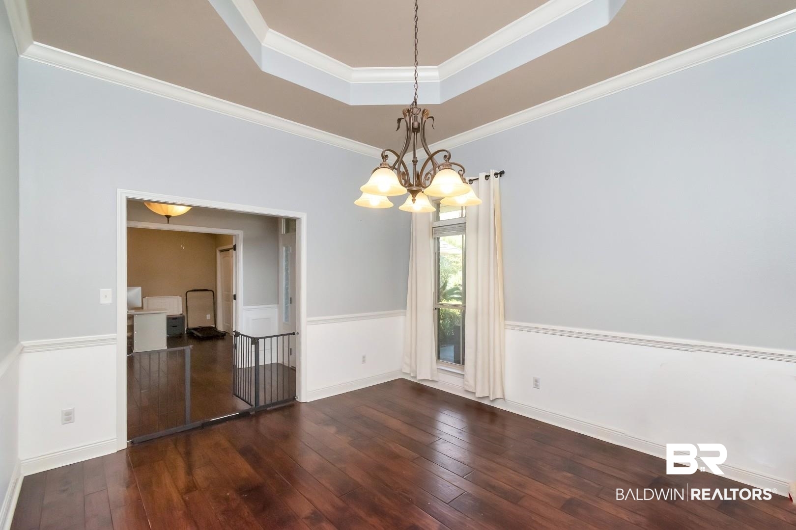 27890 Rileywood Drive Daphne, AL 36526 - Photo 13 of 49 Unfurnished dining area featuring a tray ceiling, an inviting chandelier, dark wood-style floors, and crown molding