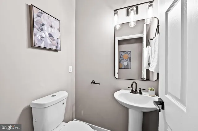 a kitchen with a sink a refrigerator and white cabinets