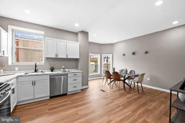 a kitchen with a table chairs refrigerator and cabinets