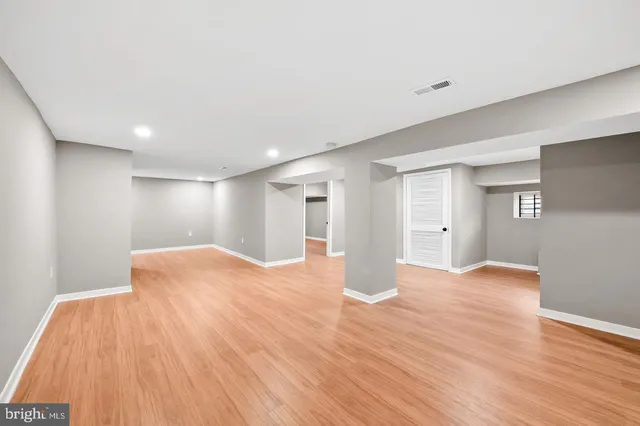a view of an empty room with wooden floor