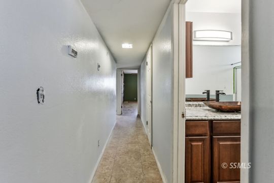 301 South Lincoln Street Ridgecrest, CA 93555 - Photo 10 of 20 a en suite bathroom with a granite countertop sink and a mirror