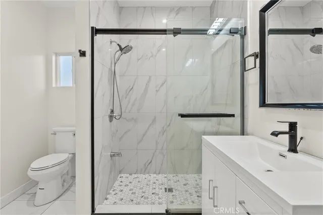 a bathroom with a shower toilet and sink