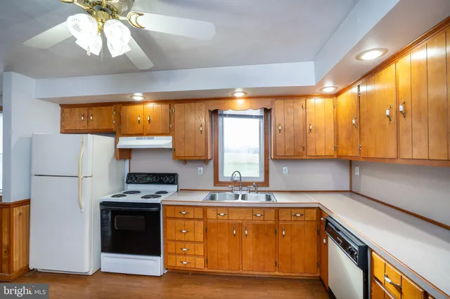 a kitchen with stainless steel appliances granite countertop a sink a stove and a refrigerator