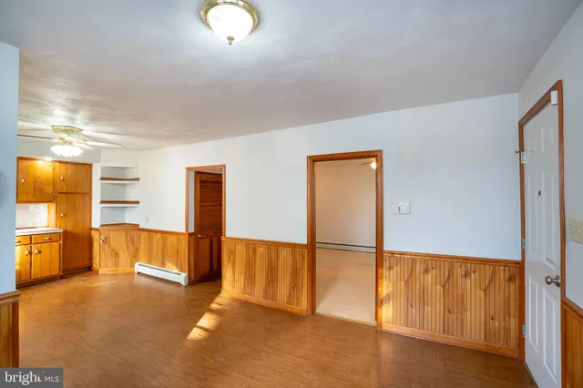 a view of a livingroom with a chandelier fan and a hallway