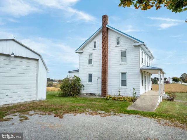 a backyard of a house with plants and barbeque oven