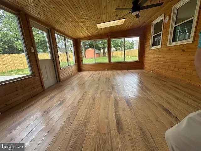 a view of an empty room and wooden floor and windows