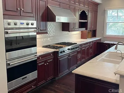 a kitchen with stainless steel appliances wooden cabinets and a stove top oven