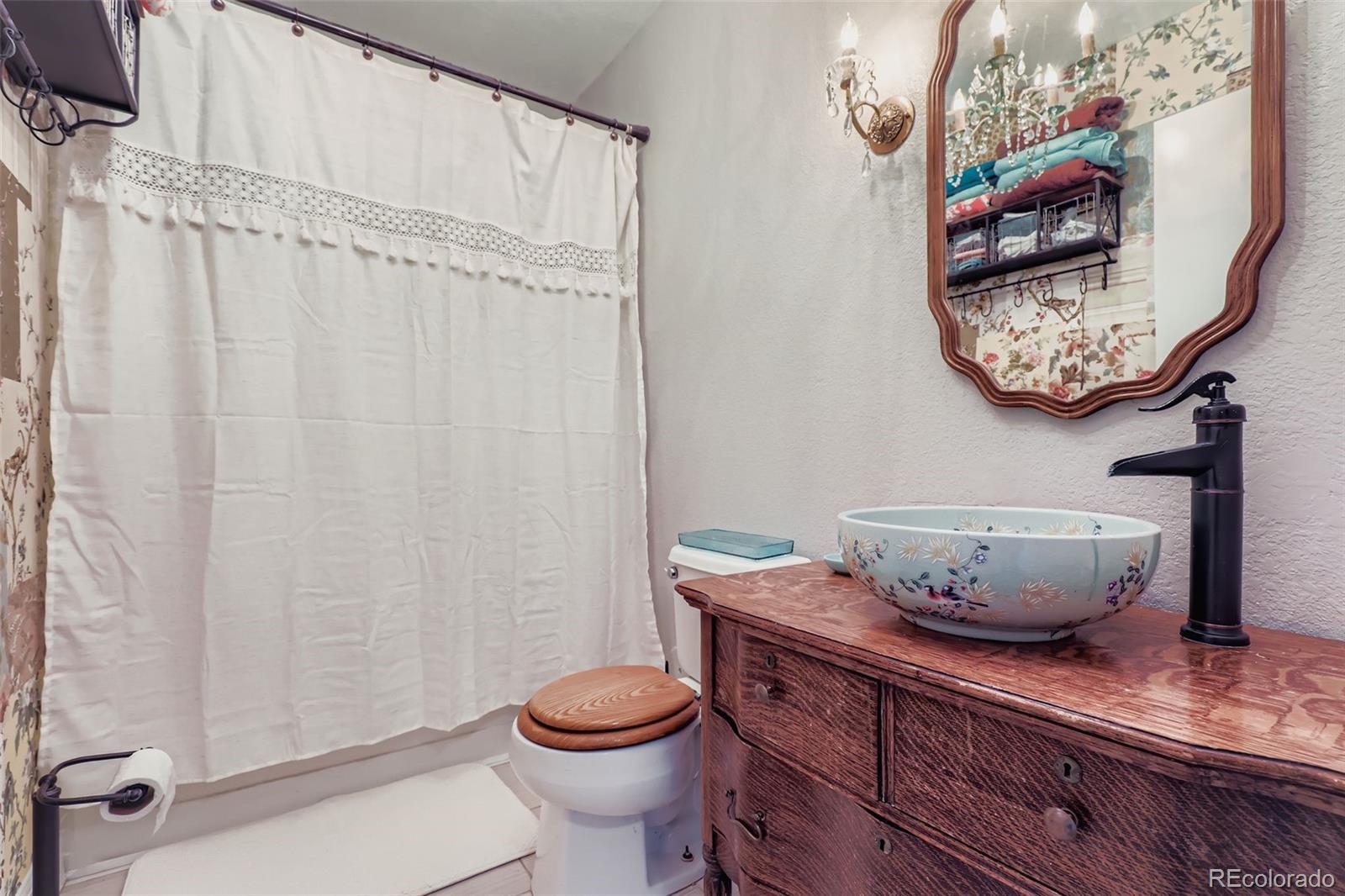 4716 Andes Street Denver, CO 80249 - Photo 11 of 27 a bathroom with a toilet a sink and a shower curtain