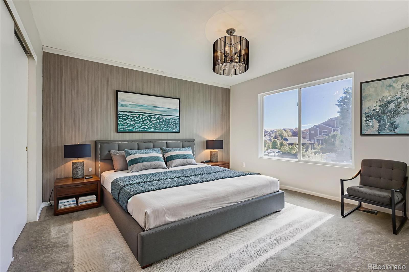 4716 Andes Street Denver, CO 80249 - Photo 19 of 27 a bedroom with a bed a couch and a chandelier