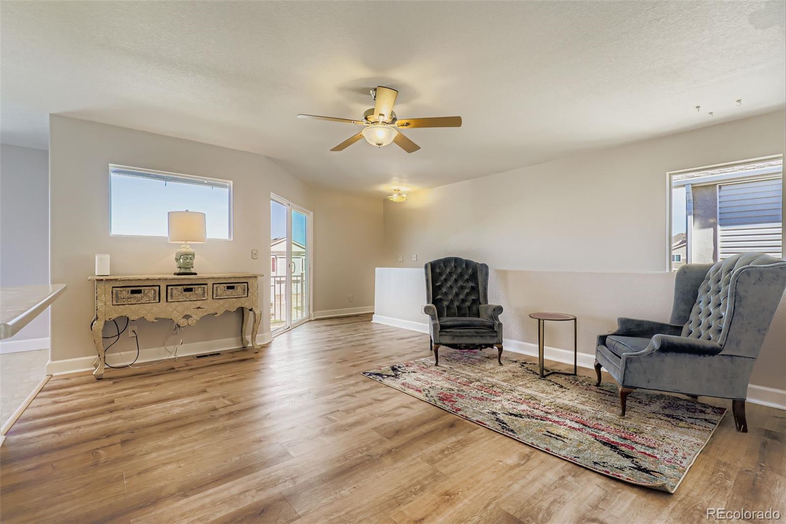 4716 Andes Street Denver, CO 80249 - Photo 2 of 5 a living room with furniture and a dining table with wooden floor