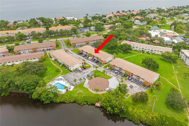 an aerial view of a house with a yard and lake view