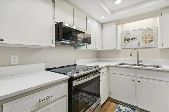 a kitchen with a sink stove and microwave