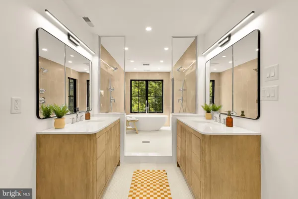 a bathroom with a double vanity sink mirror and bathtub
