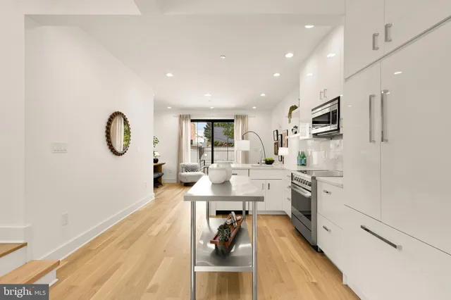 a kitchen with white cabinets and stainless steel appliances