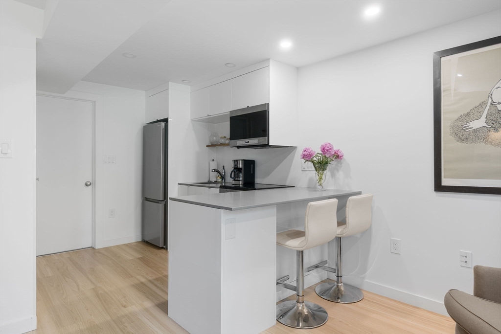 99 Upland Road Cambridge, MA 02140 - Photo 5 of 16 a kitchen with stainless steel appliances kitchen island granite countertop a refrigerator and a stove top oven