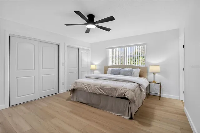 a spacious bedroom with a bed and a ceiling fan