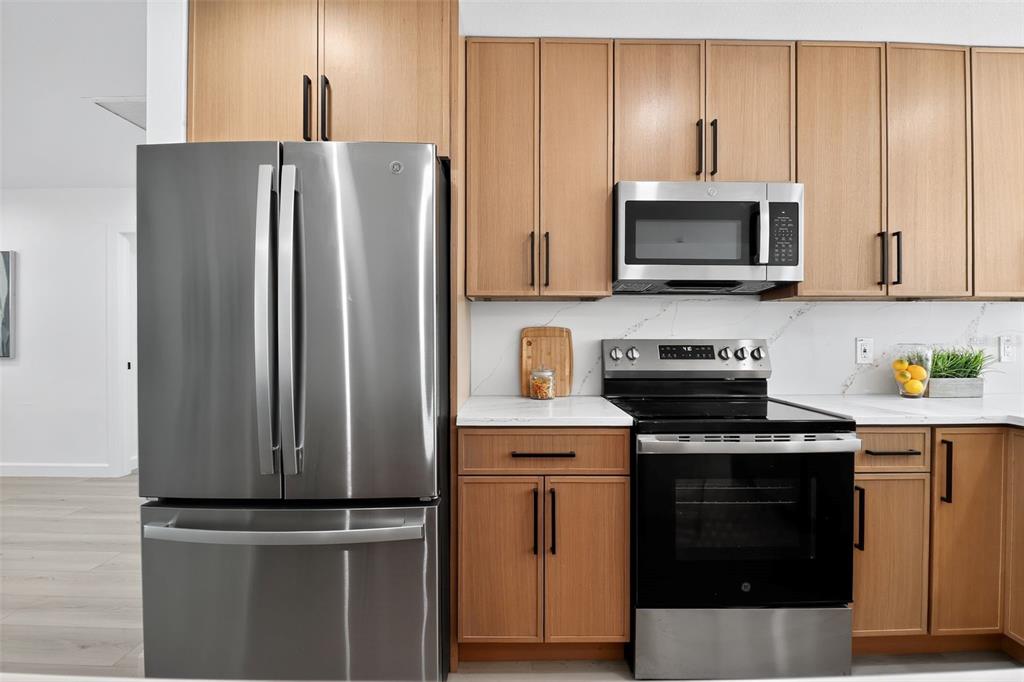 4210 Palm Drive Punta Gorda, FL 33950 - Photo 10 of 30 a kitchen with stainless steel appliances white cabinets and a stove top oven