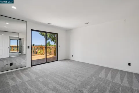 a view of an empty room with a fireplace and a window