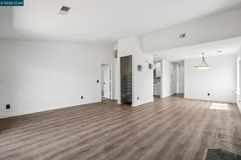 a view of an empty room with wooden floor
